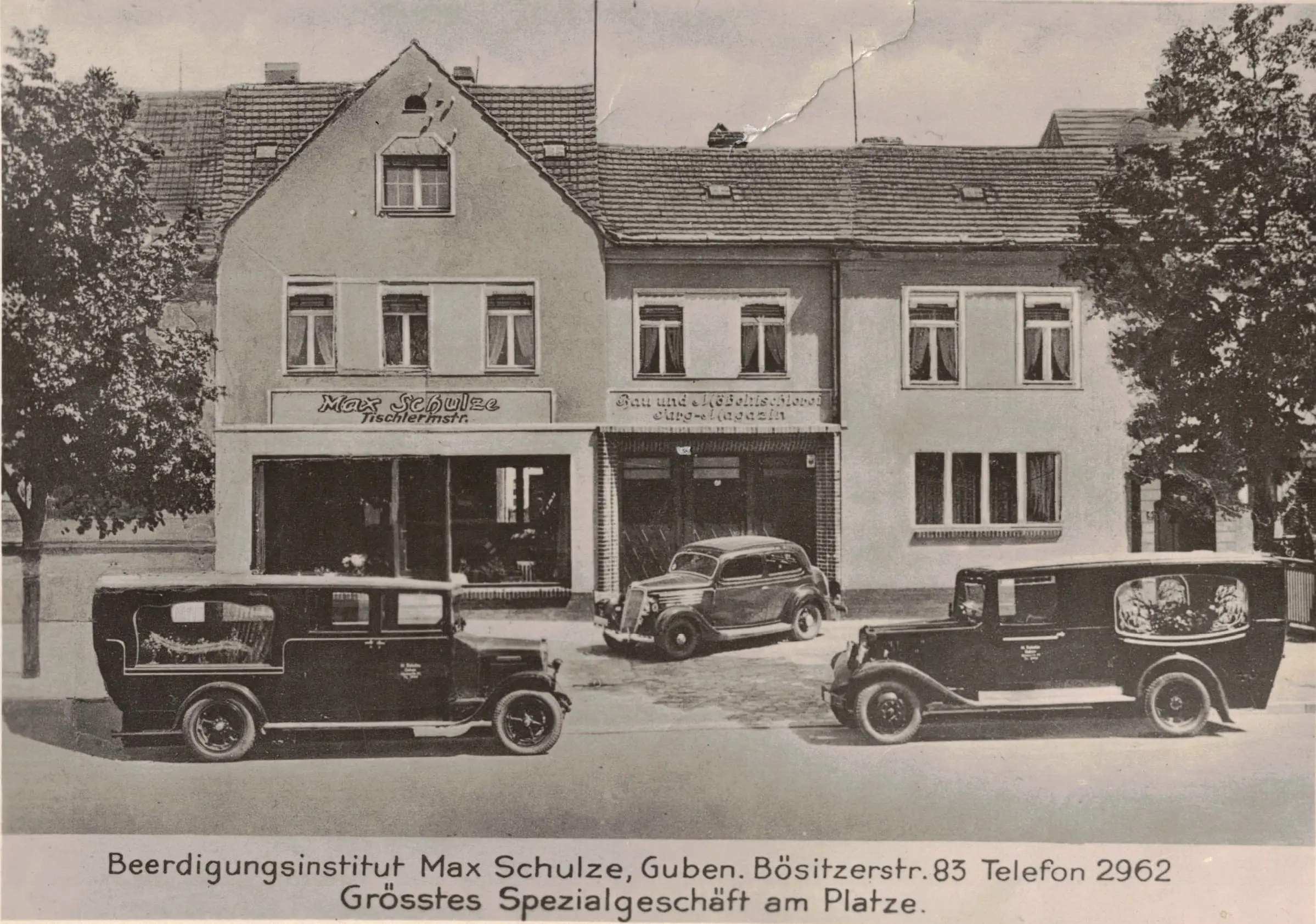 Historische Aufnahme des Beerdigungsinstituts Max Schulze in Guben mit Bestattungsfahrzeugen vor dem Gebäude.