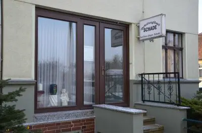 Eingangsbereich des Bestattungshauses Schade mit Firmenschild an der Fassade.